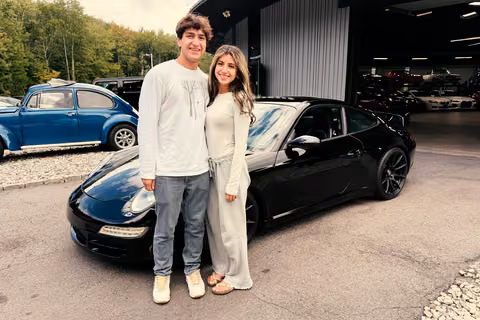 Customers beside their black 2006 Porsche 911 Carrera S at Buonauto Enterprises