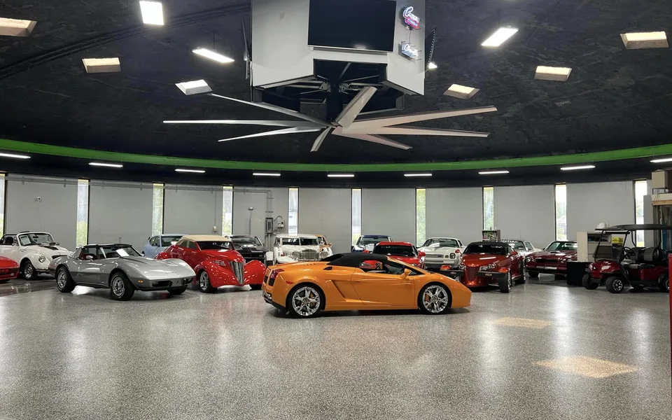 Orange Lamborghini surrounded by classic and specialty cars in the Buonauto Enterprises showroom