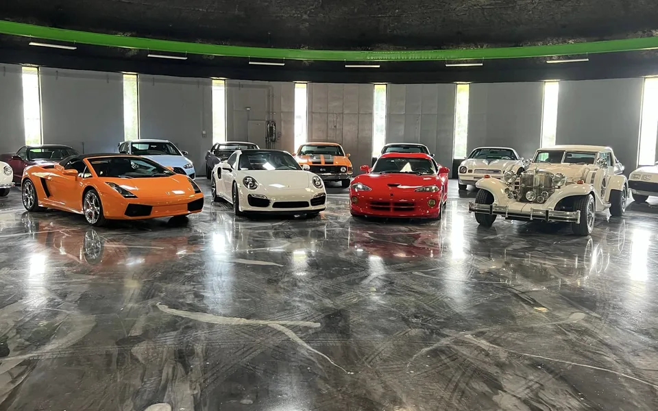 Exotic and classic vehicles displayed on the polished Buonauto Enterprises showroom floor